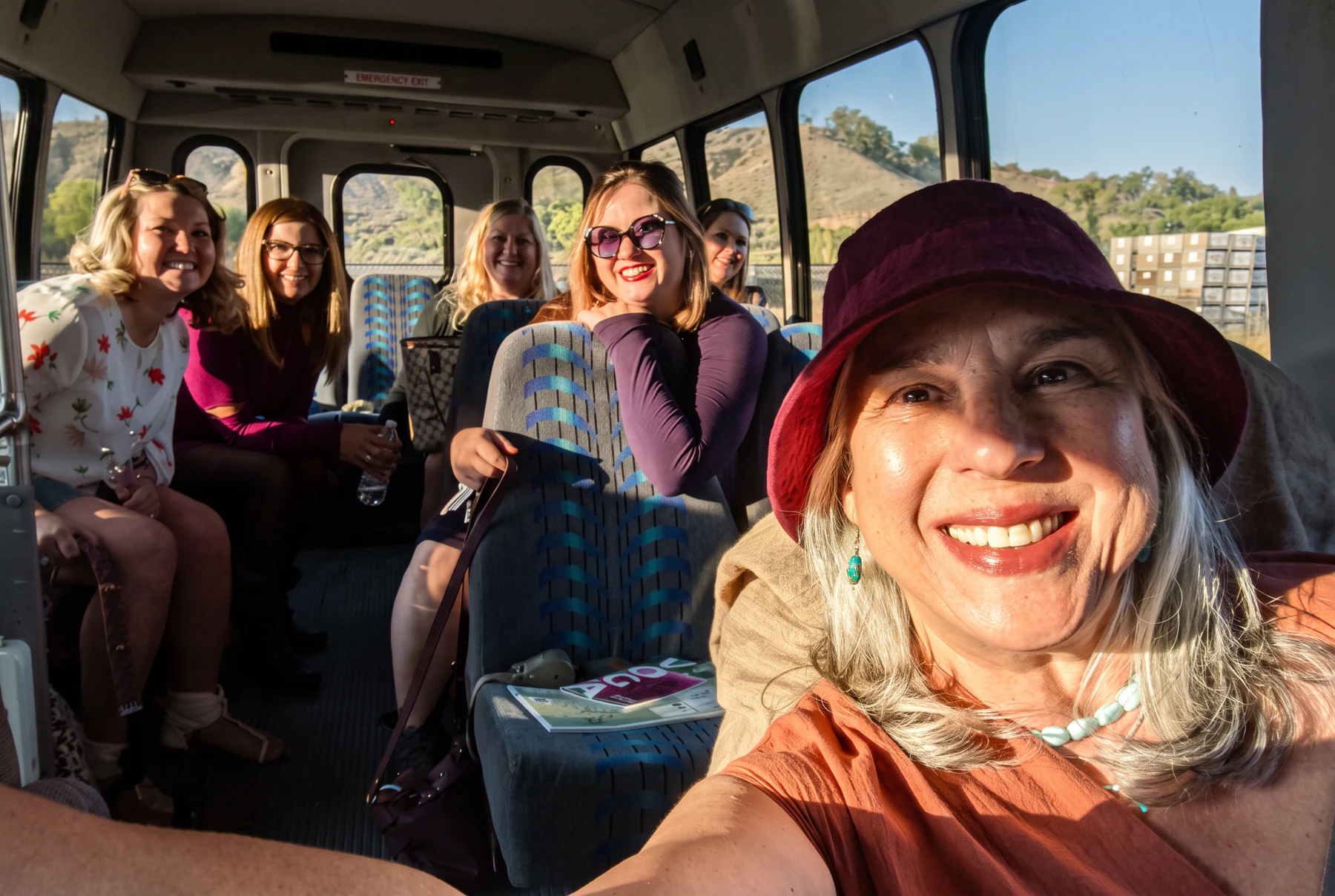 Jo Ann smiling with a tour group inside Hoss beneath the high roof and panoramic windows